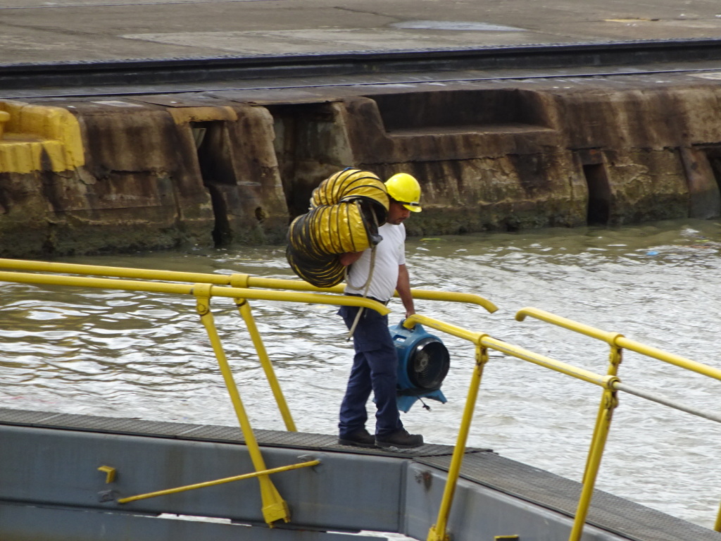 Worker crossing one of the gates that keeps the water in the lock. When the gate is engaged handrails pop us and workers walk across the lock.