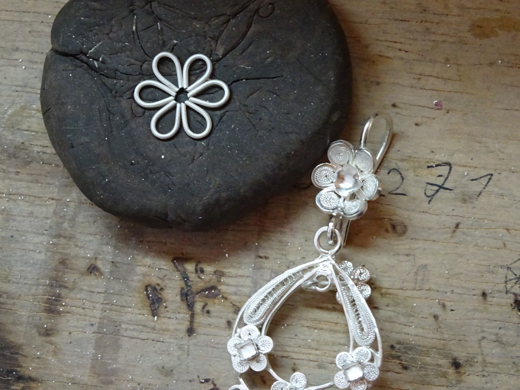 The flower next to the flower filigree earring he's matching. He added gesso on top of this and, once it dried, he pulled it up and then soldered on the gesso.