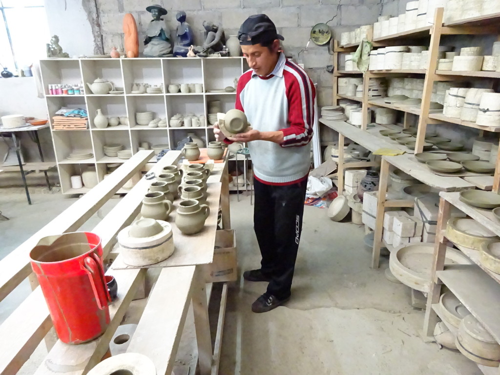 After drying for a day or so, he can remove the mold and then the mug will air dry for another day before being cleaned and carved. Here you can also see the wall of molds on the right and some of Angel's figurative sculptures in the very back.