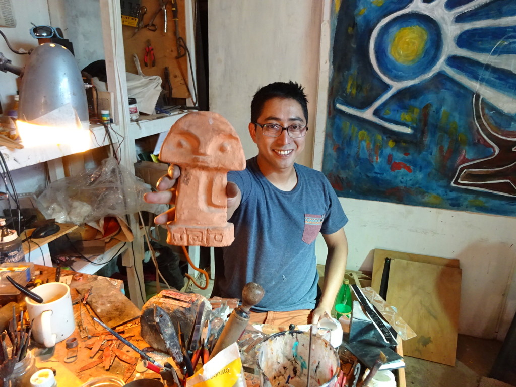 Cristian with one of his small sculptures inspired by the ancient local culture.