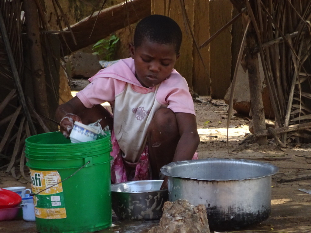 Amboni is this kind of poor. This girl washes dishes instead of going to school. Moment earlier she was using a knife the size of her arm to peel vegetable with incredible speed.