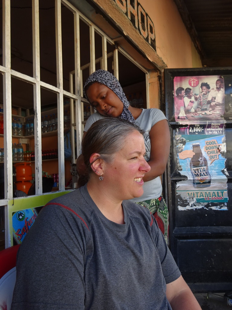 Our friend Vicky gives me a new fancy braid/bun infront of Ruth Place. That's where I learned beauty does has a price.