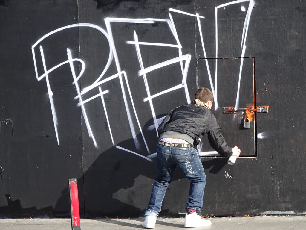 Just getting started on his graffiti art. If you look on the lower left you can see that he first used a roller to paint out a piece behind and was making his own new creation.