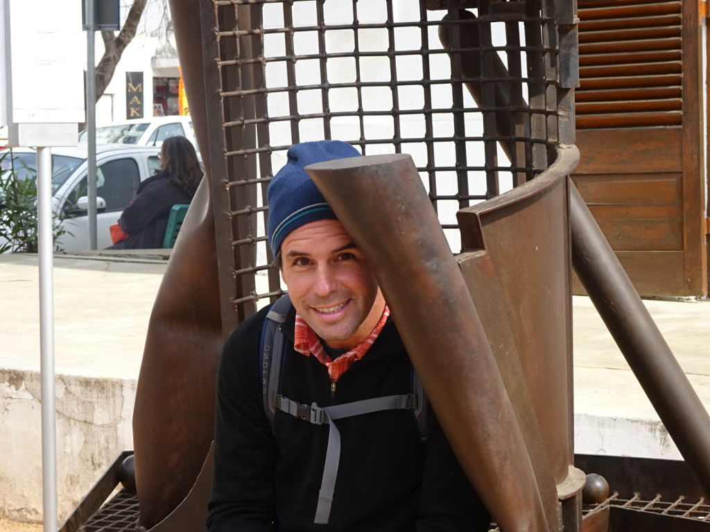 Aaron sitting in a weird but cool sculpture.
