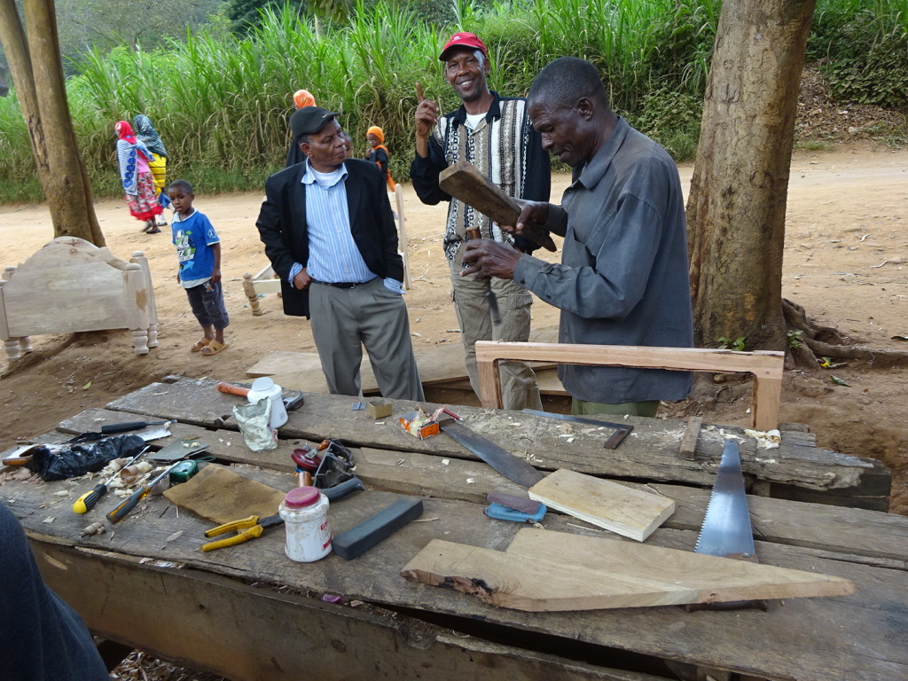 Cutting the hinge spots for a door frame in Tanzania - all you need is a piece of wood and something to use for a chisel.